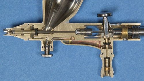 Cross-section of a precision airbrush highlighting its internal components and sophisticated design.